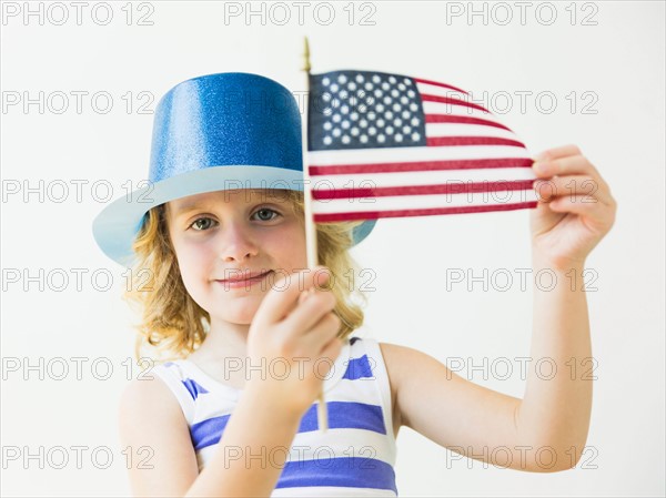 Portrait of blonde girl (4-5) holding American flag