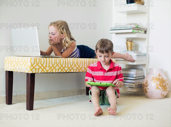 Kids (4-5, 6-7) using laptop and digital tablet indoors