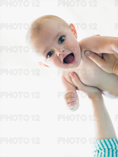 Baby boy (6-11 months) held by mother