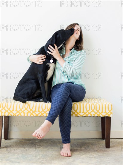 Dog licking woman on face