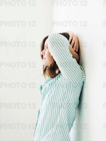 Young woman leaning on wall