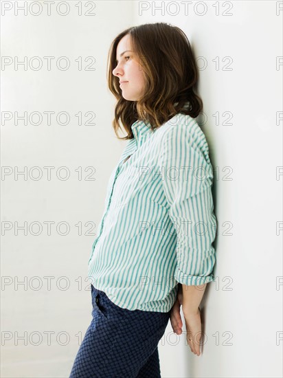 Young woman leaning on wall