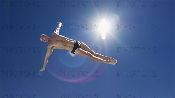 Athletic swimmer jumping.