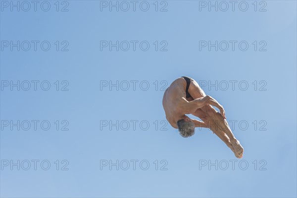 Athletic swimmer jumping.