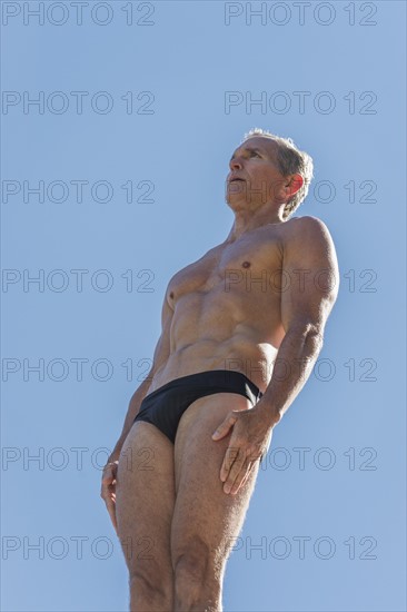 Athletic swimmer against blue sky.