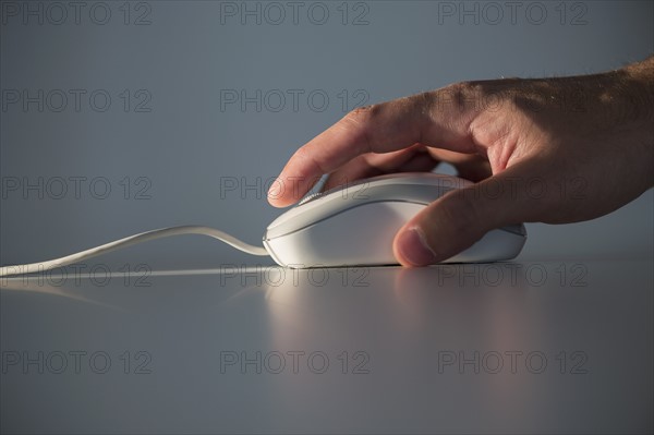 Studio shot of hand using computer mouse.