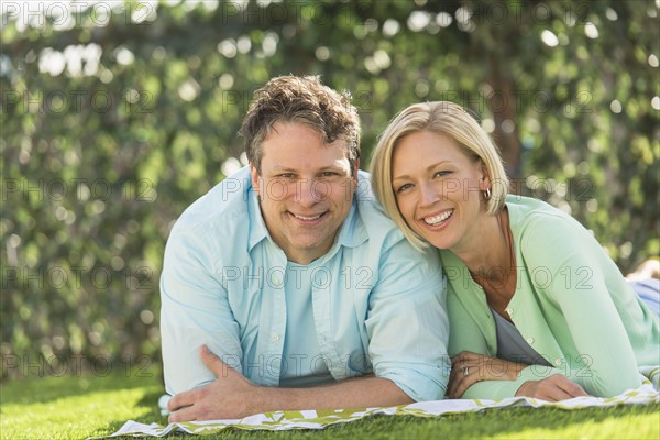 Couple lying on grass.