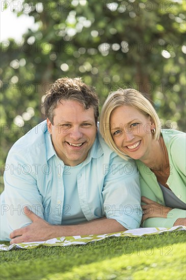 Couple lying on grass.