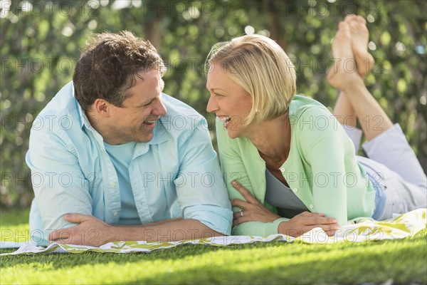 Couple lying on grass.