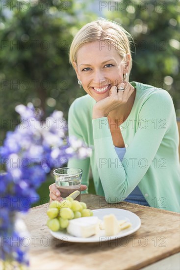 Woman sitting at table outdoors.