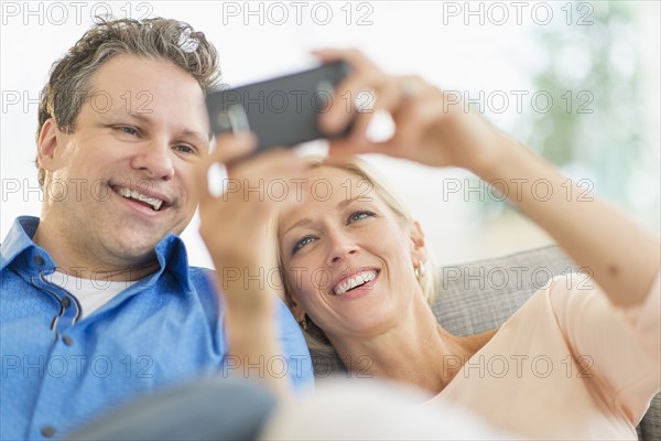 Couple taking self-portrait photo with smartphone.