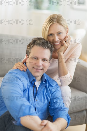 Portrait of couple sitting on sofa.