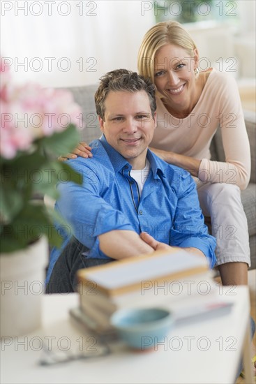 Portrait of couple sitting on sofa.