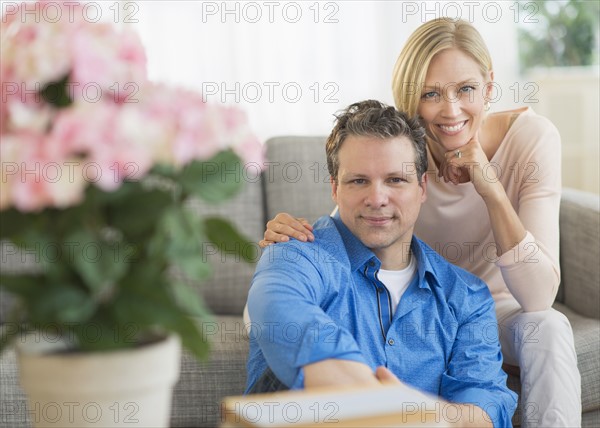 Portrait of couple sitting on sofa.