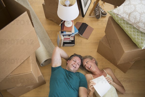 Couple lying on floor of new home.