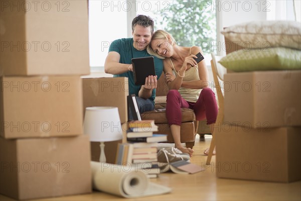 Couple using tablet pc in new home.