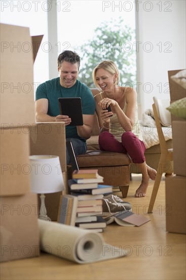 Couple using tablet pc in new home.