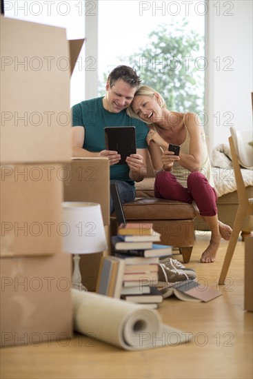 Couple using tablet pc in new home.