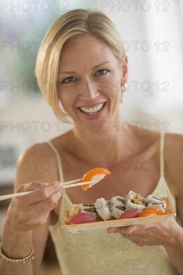 Portrait of woman eating sushi.