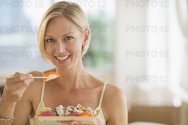 Portrait of woman eating sushi.