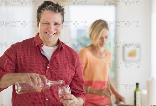 Couple cooking at home, focus on man.