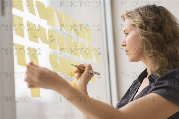 Business woman arranging yellow notes.