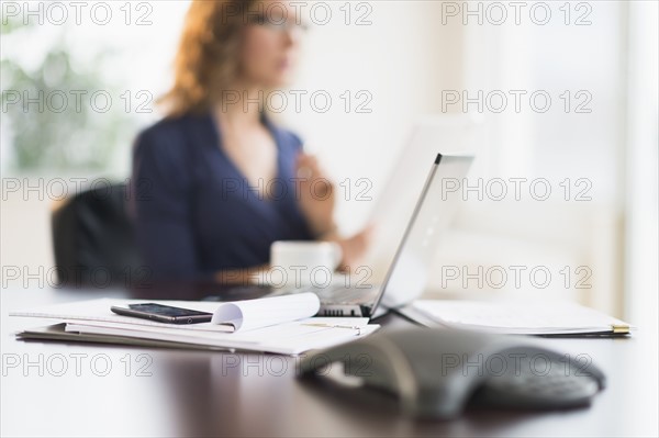 Office desk with defocused businesswoman.