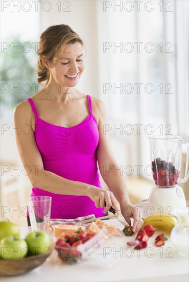 Woman preparing fruit drink.