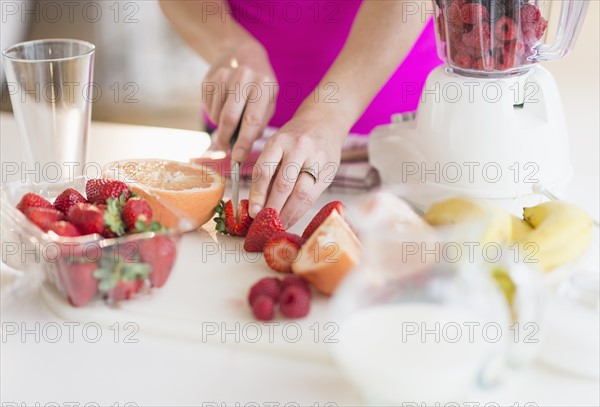 Woman slicing strawberries.