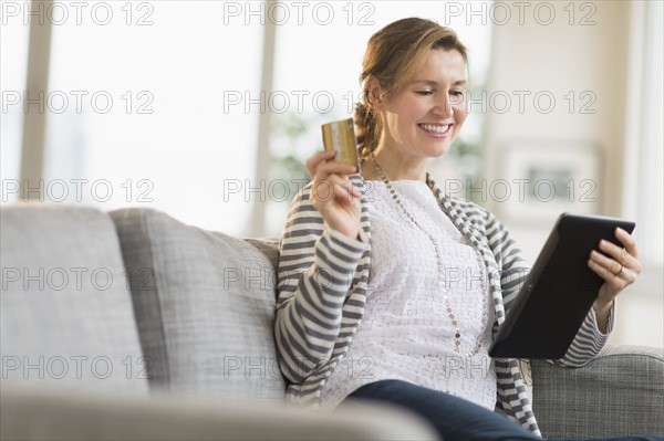 Woman holding tablet pc and credit card.