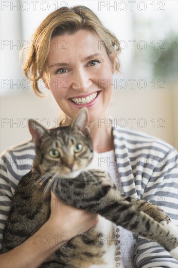 Portrait of woman holding cat.