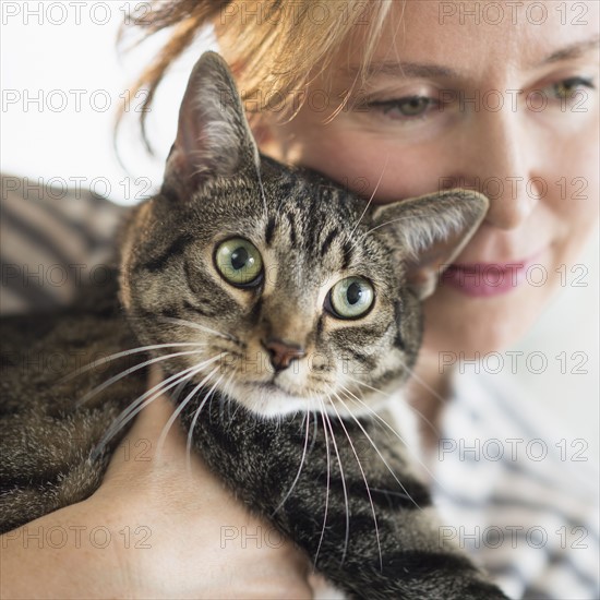 Woman hugging cat.