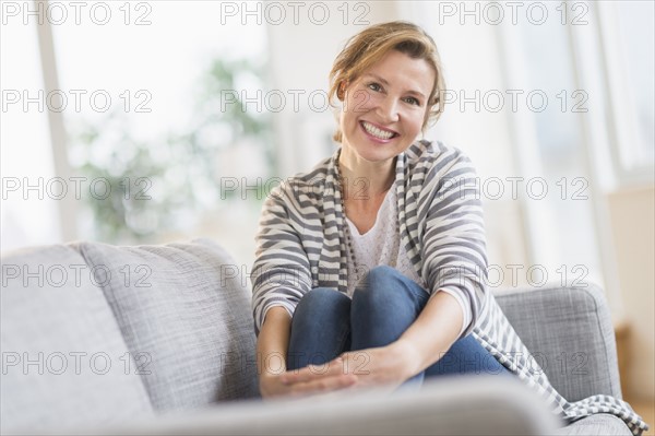 Portrait of woman sitting on sofa.