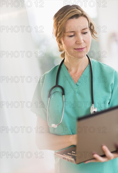 Female doctor using laptop.