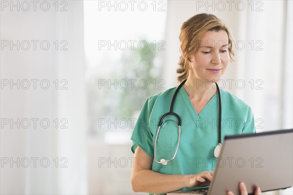 Female doctor using laptop.