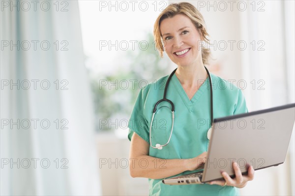 Portrait of female doctor using laptop.