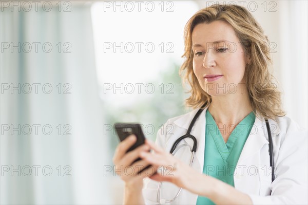 Female doctor using phone.