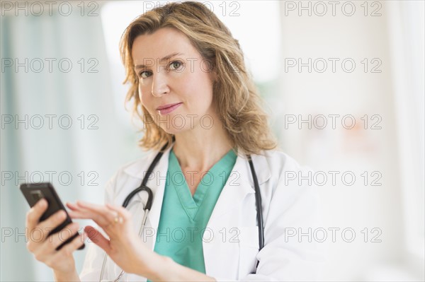 Portrait of female doctor using phone.