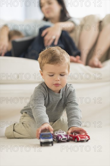 Boy (12-17 months) playing on floor.