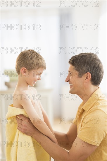 Father with son (6-7) wrapped in towel.