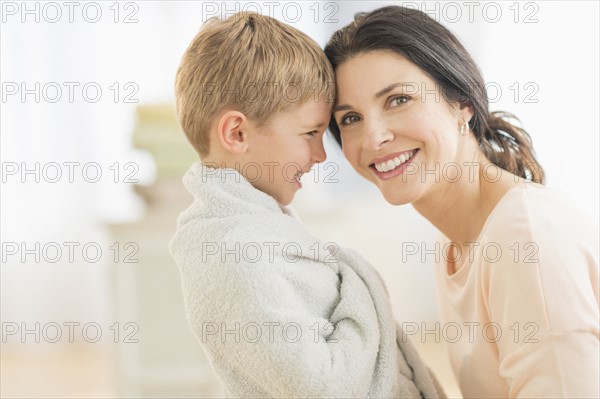 Mother with son (6-7) wrapped in towel.