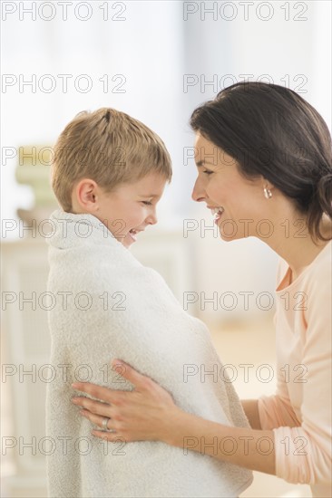 Mother with son (6-7) wrapped in towel.