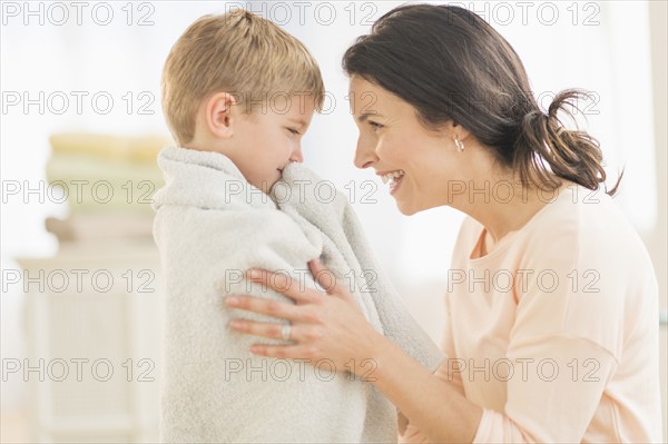 Mother with son (6-7) wrapped in towel.