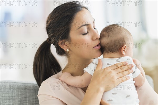Mother embracing baby boy (2-5 months).