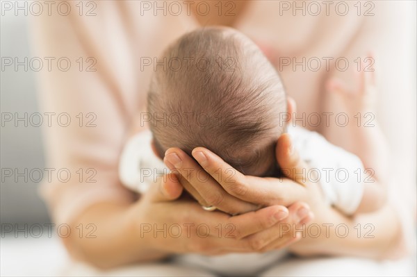 Mother holding baby boy (2-5 months).