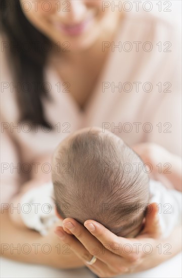 Mother holding baby boy (2-5 months).