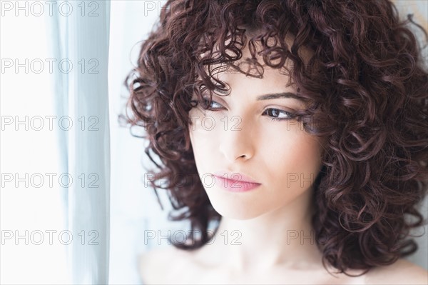 Beautiful woman looking through window.