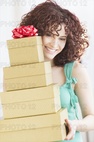 Woman holding stack of gifts.