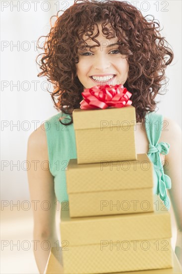 Woman holding stack of gifts.