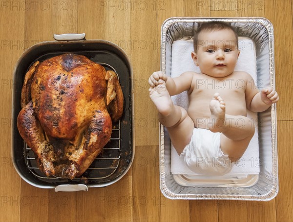 Baked turkey and baby girl (2-5 months) in baking dish.